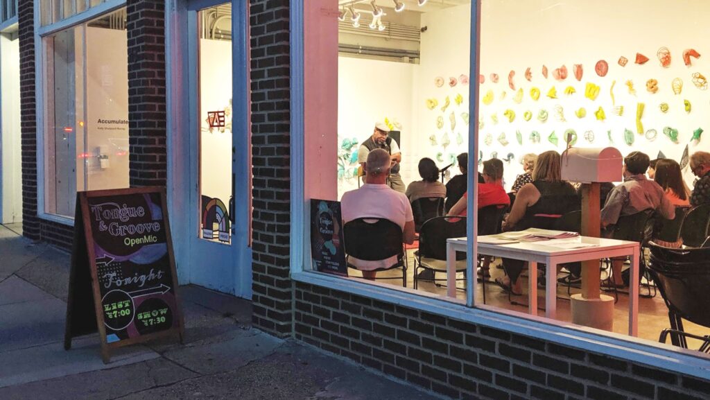 view into the window of an open mic with an attentive audience