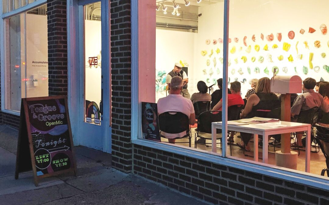 view into the window of an open mic with an attentive audience