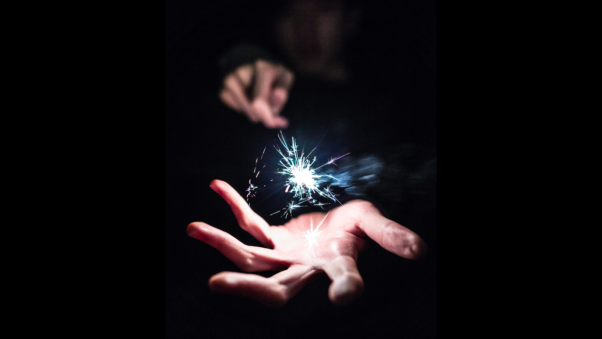 a hand with a sparkler above it
