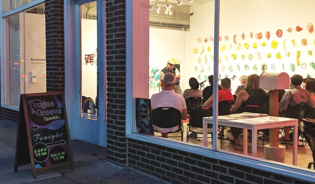 open mic night at an art gallery viewed from the sidewalk